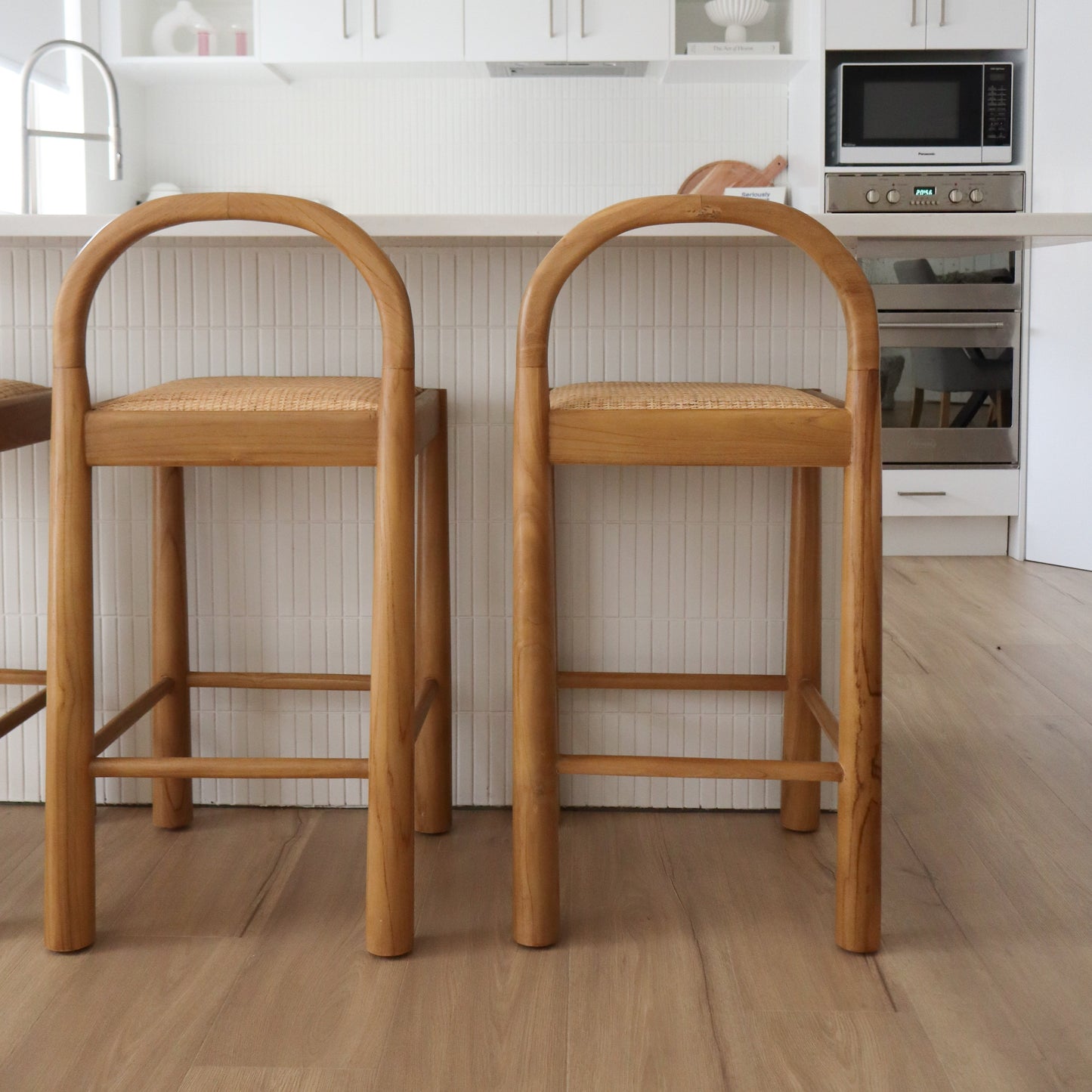 Two wooden bar stools in a modern kitchen setting.